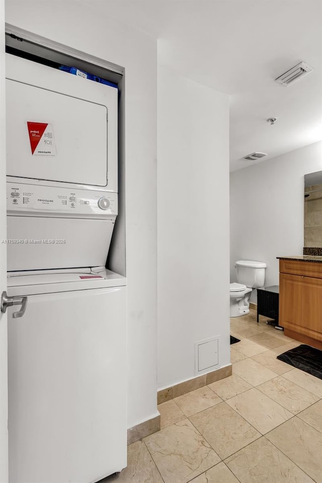1 Glen Royal Pkwy Unit 1207, Miami, FL 33125 - laundry area with baseboards, stacked washer / drying machine, visible vents, and laundry area