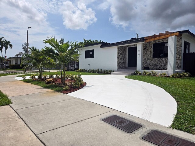 5152 SW 6th, Miami, FL 33134 - view of front of home with stone siding, curved driveway, stucco siding, and a front lawn