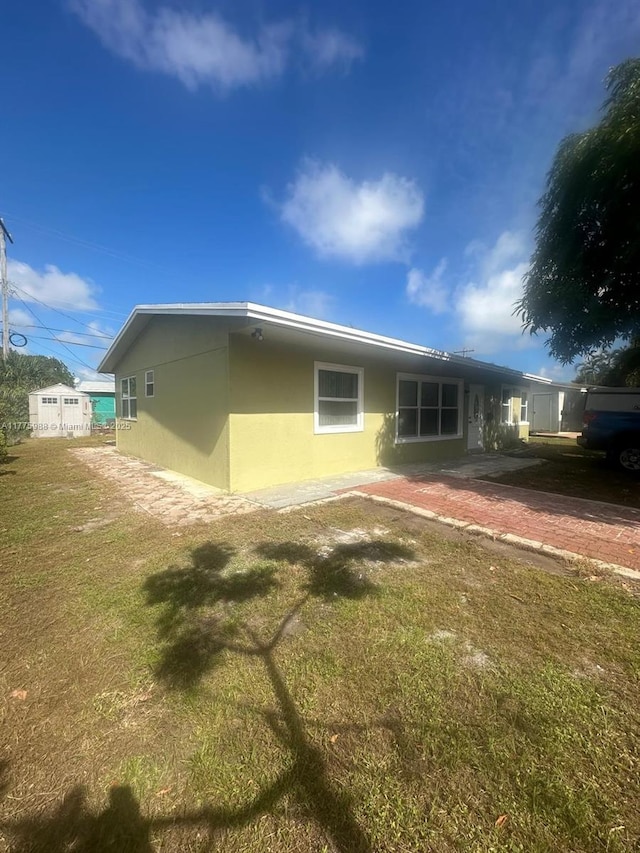 1611 NE 32nd Pl, Pompano Beach, FL 33064 - back of house featuring stucco siding and a lawn