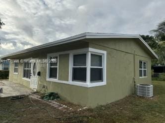 1611 NE 32nd Pl, Pompano Beach, FL 33064 - view of side of home featuring central AC, a patio area, and stucco siding