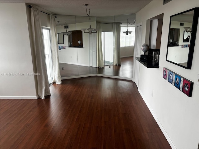 unfurnished room with baseboards and wood finished floors