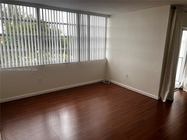 spare room with wood finished floors and baseboards