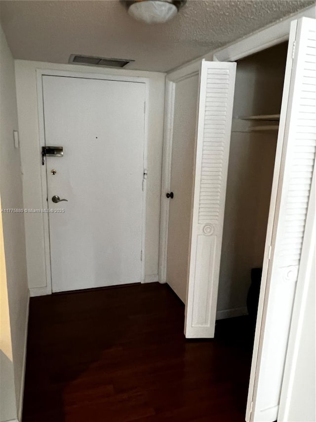 hallway with visible vents and dark wood-style floors