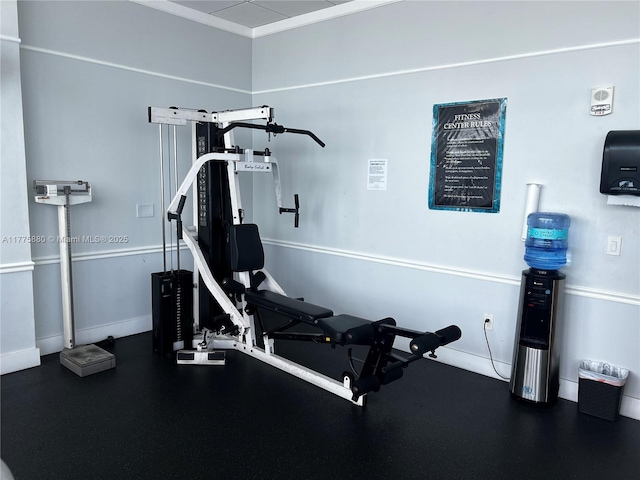 exercise room featuring baseboards and crown molding