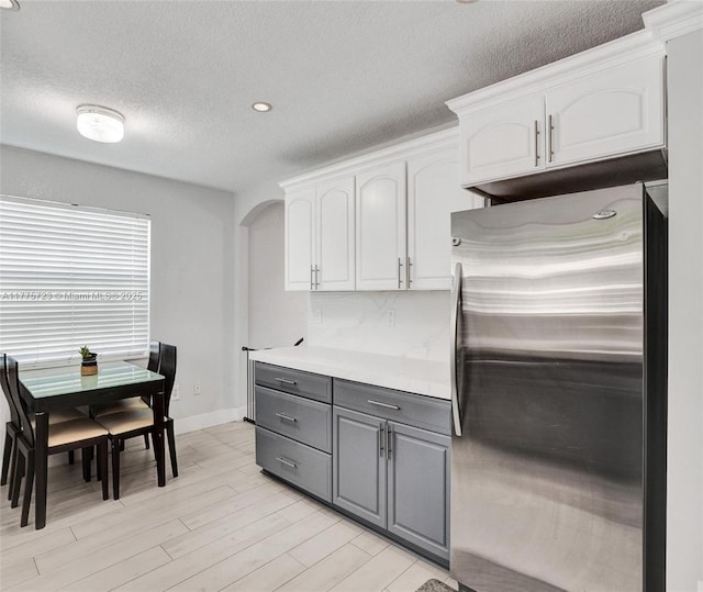 217 SE 5th St, Dania Beach, FL 33004 - kitchen featuring freestanding refrigerator, arched walkways, gray cabinets, white cabinetry, and light countertops
