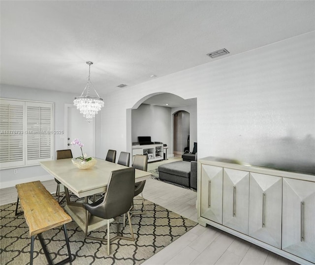 217 SE 5th St, Dania Beach, FL 33004 - dining room with arched walkways, a chandelier, and light wood-type flooring
