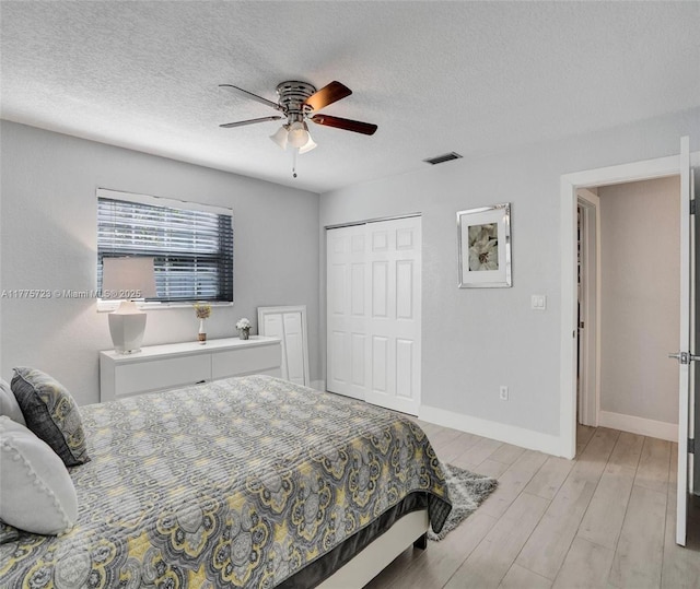 217 SE 5th St, Dania Beach, FL 33004 - bedroom featuring light wood-style floors, a closet, a textured ceiling, baseboards, and a ceiling fan