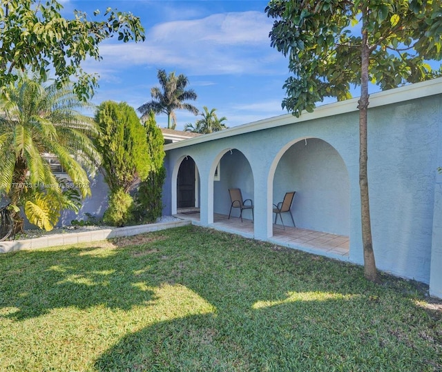 217 SE 5th St, Dania Beach, FL 33004 - back of house featuring stucco siding, a lawn, and a patio