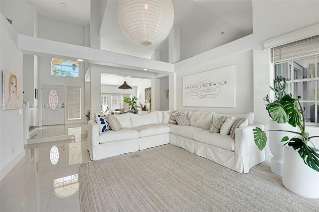 tiled living room with visible vents and a towering ceiling