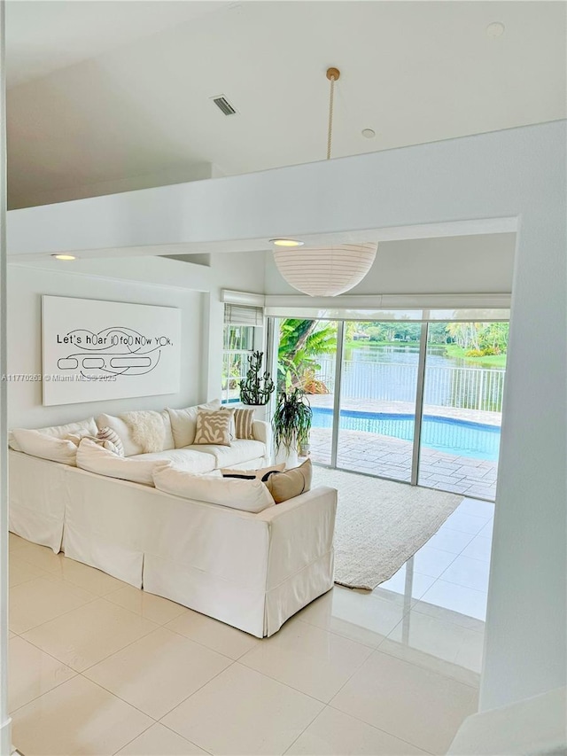living area with visible vents, a wealth of natural light, and light tile patterned floors