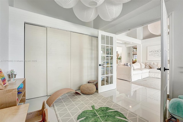 tiled bedroom featuring french doors and a closet