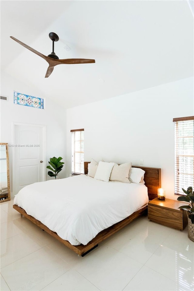 bedroom featuring visible vents, a ceiling fan, light tile patterned floors, and vaulted ceiling