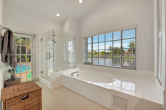 bathroom featuring tile patterned floors, a tub with jets, vaulted ceiling, visible vents, and a stall shower