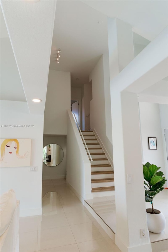 stairway with tile patterned floors, baseboards, and recessed lighting