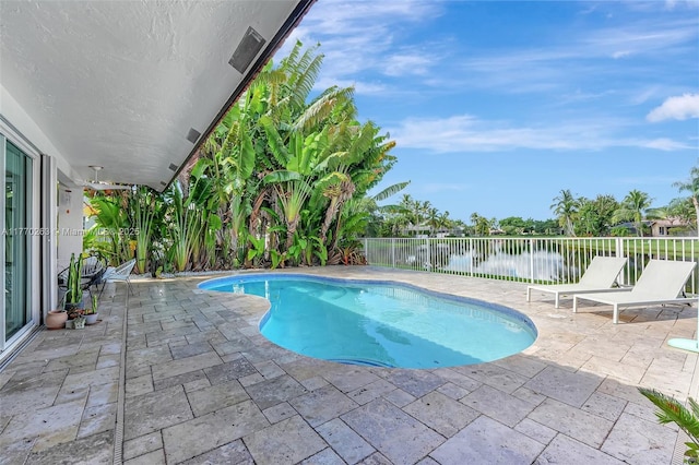 view of pool featuring a water view, a fenced in pool, a fenced backyard, and a patio area