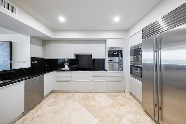 1331 Brickell Bay Dr Unit 3305, Miami, FL 33131 - kitchen with built in appliances, white cabinetry, dark countertops, backsplash, and recessed lighting
