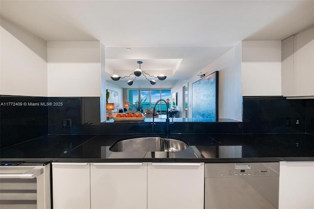 1331 Brickell Bay Dr Unit 3305, Miami, FL 33131 - kitchen with stainless steel dishwasher, white cabinets, dark countertops, and backsplash