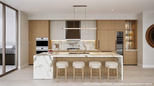 kitchen with modern cabinets, an island with sink, light stone countertops, and decorative backsplash