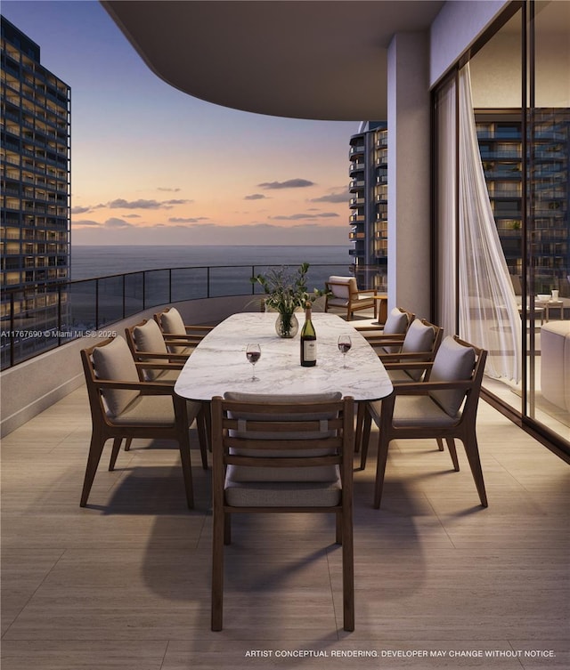exterior space featuring a balcony, a water view, and outdoor dining space