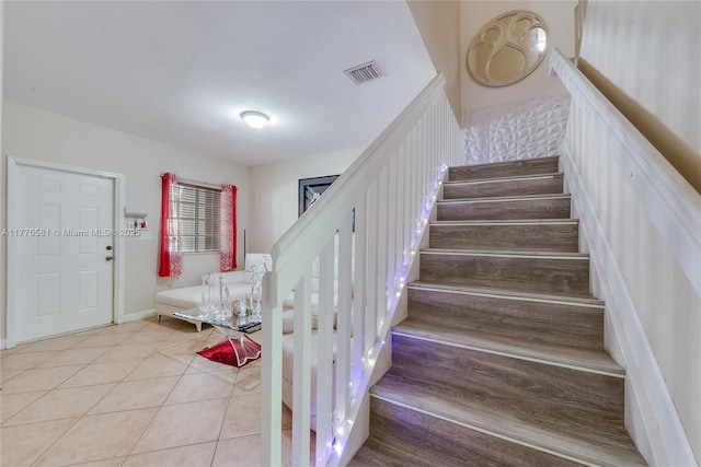 staircase with visible vents and tile patterned floors