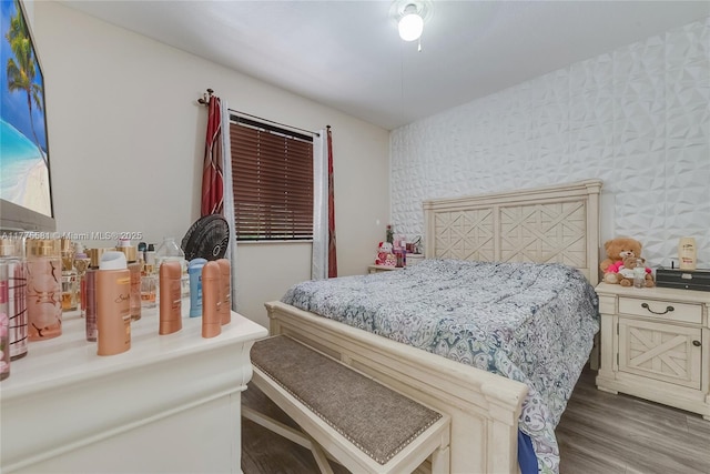 bedroom featuring wood finished floors and wallpapered walls