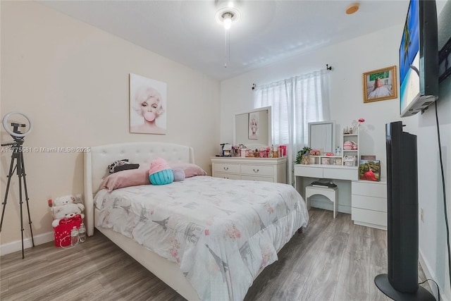 bedroom with wood finished floors and baseboards