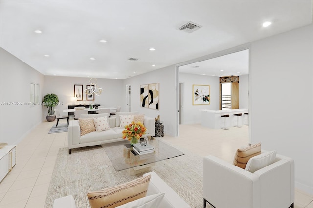 living area with light tile patterned flooring, visible vents, a notable chandelier, and recessed lighting