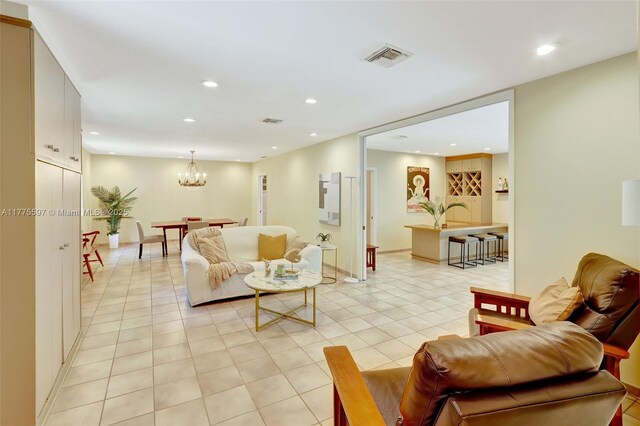 living area with light tile patterned floors, a notable chandelier, visible vents, and recessed lighting