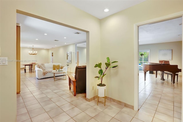hallway with recessed lighting, an inviting chandelier, visible vents, light tile patterned flooring, and baseboards
