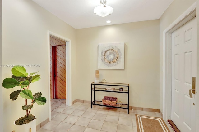 hallway featuring baseboards, recessed lighting, and light tile patterned floors
