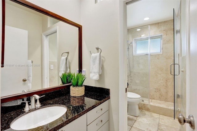 bathroom with toilet, vanity, and a stall shower