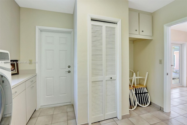 laundry room with cabinet space, washer / dryer, and light tile patterned floors