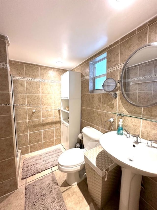 full bath with tile patterned flooring, toilet, tile walls, and a shower stall