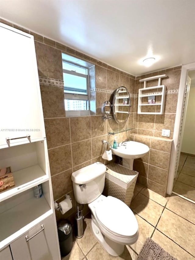 bathroom with tile patterned floors, toilet, and tile walls