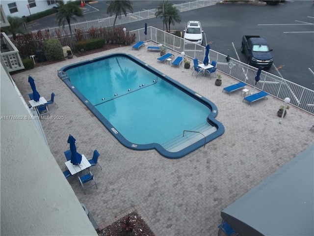 community pool featuring fence and a patio