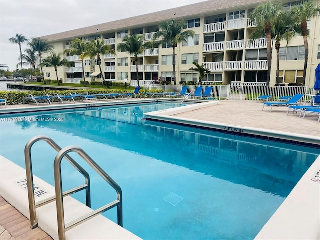 pool with fence and a patio area