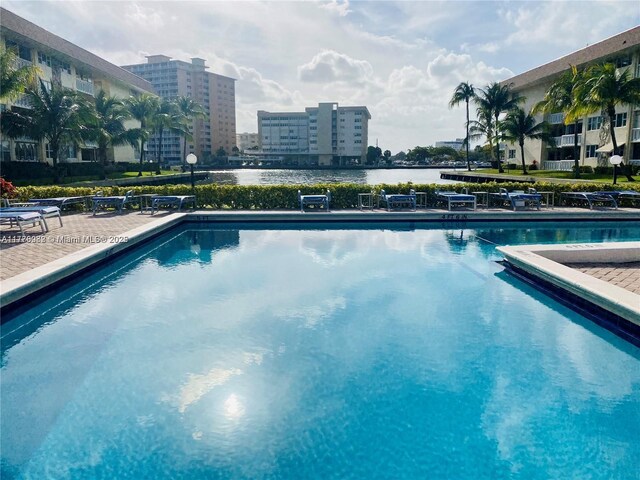community pool with a water view and a city view