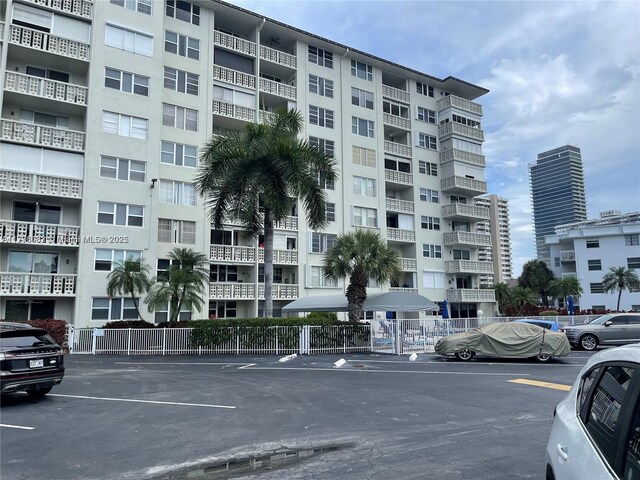 1893 S Ocean Dr Unit 903, Hallandale Beach, FL 33009 - view of building exterior with uncovered parking and fence