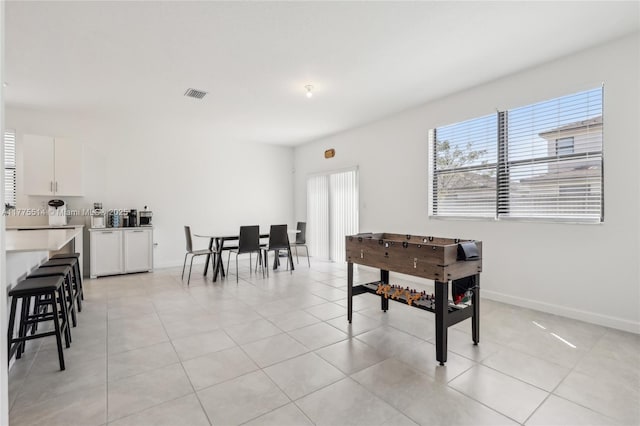 playroom featuring baseboards, visible vents, and light tile patterned floors
