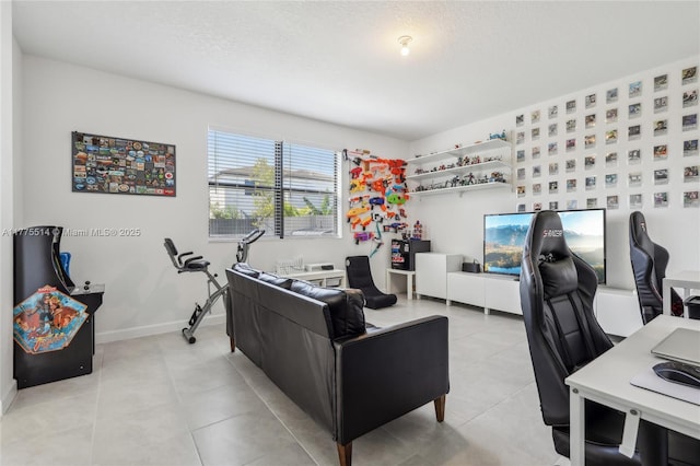 home office with light tile patterned floors, a textured ceiling, and baseboards