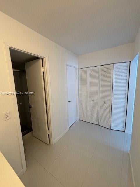 401 SE Golden Isles Dr Unit 712, Hallandale Beach, FL 33009 - unfurnished bedroom with light tile patterned floors, baseboards, and a closet