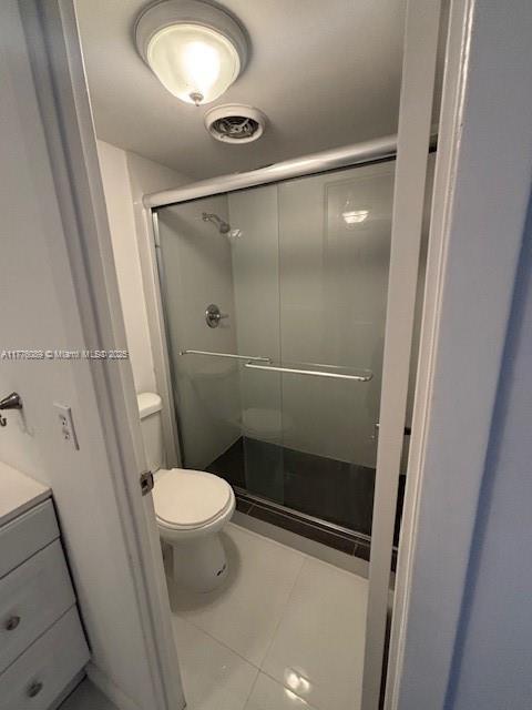 401 SE Golden Isles Dr Unit 712, Hallandale Beach, FL 33009 - bathroom featuring a stall shower, toilet, tile patterned floors, and vanity