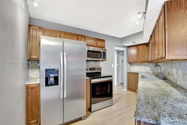 6911 Environ Blvd Unit 3L, Lauderhill, FL 33319 - kitchen with appliances with stainless steel finishes, a sink, backsplash, light wood-type flooring, and brown cabinets