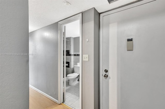 6911 Environ Blvd Unit 3L, Lauderhill, FL 33319 - hall featuring a textured ceiling, baseboards, and light wood-style flooring