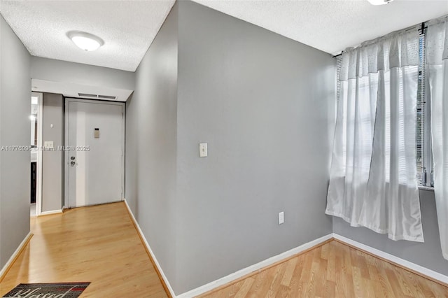 6911 Environ Blvd Unit 3L, Lauderhill, FL 33319 - hall with a textured ceiling, wood finished floors, and baseboards