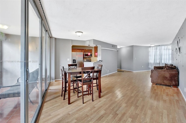 6911 Environ Blvd Unit 3L, Lauderhill, FL 33319 - dining area with light wood-style floors, a textured ceiling, and baseboards
