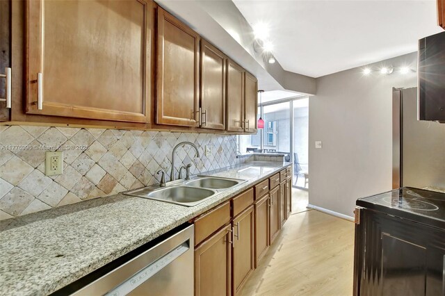 6911 Environ Blvd Unit 3L, Lauderhill, FL 33319 - kitchen with appliances with stainless steel finishes, backsplash, a sink, light wood finished floors, and brown cabinetry
