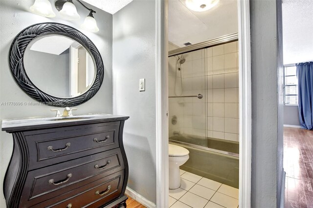6911 Environ Blvd Unit 3L, Lauderhill, FL 33319 - full bathroom with toilet, bath / shower combo with glass door, baseboards, vanity, and tile patterned flooring
