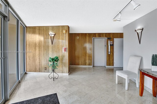 6911 Environ Blvd Unit 3L, Lauderhill, FL 33319 - unfurnished room featuring wooden walls, rail lighting, a textured ceiling, and baseboards