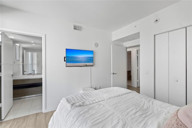 bedroom featuring visible vents, connected bathroom, and a closet
